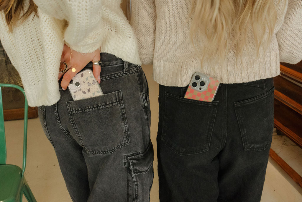 two cool phone cases for iphone sticking out of two girl's pockets