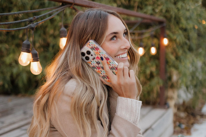 Woman sitting outdoors talking on a phone and holding a Coca-Cola bottle.